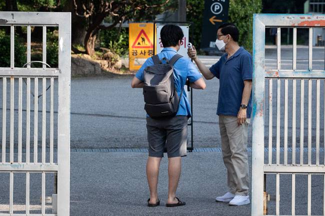 8월 26일 서울 한 고등학교에서 고3 학생이 등교 전 교문에서 체온을 확인받고 있다. [뉴스1]
