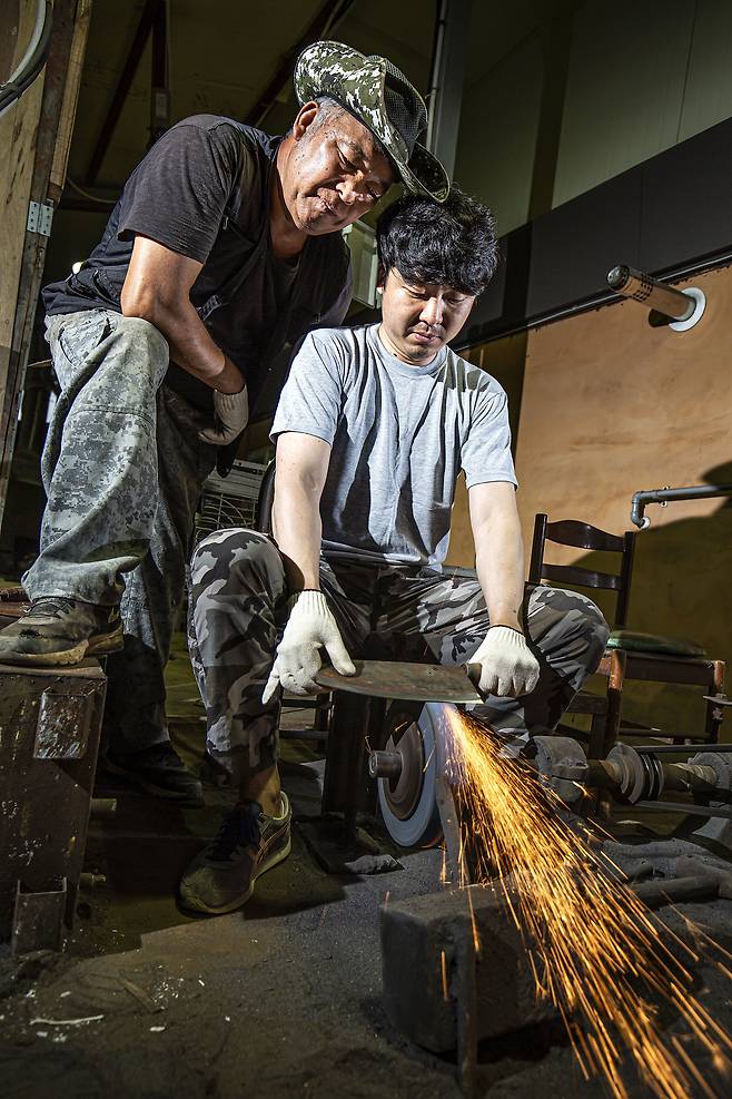 대전 한밭대장간에서 아버지 전만배가 아들 전종렬씨의 칼 연마하는 모습을 지켜보고 있다. 전만배씨는 “스타일이 다르다 뿐이지 아들의 칼 가는 솜씨는 나와 대등한 수준"이라고 했다. /김종연 영상미디어 기자