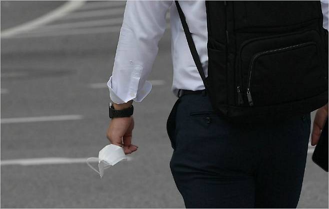 사회적 거리두기가 2단계로 완화된 14일 오전 서울 광화문 인근에서 한 사민이 마스크를 손에 들고 이동하고 있다. 이한형기자