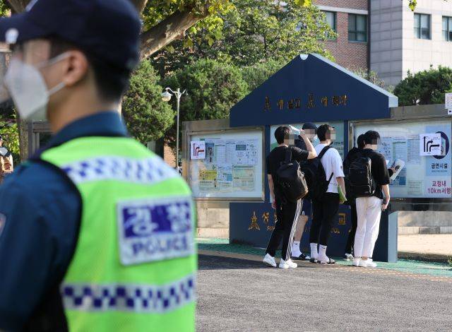 19일 오전 서울 시내 한 학교에 마련된 순경공채 필기시험장에서 응시생들이 수험표를 확인받은 뒤 입장하고 있다. 연합뉴스