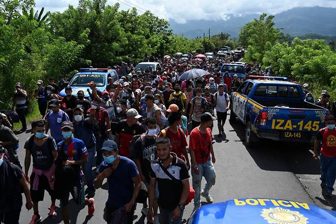 온두라스 이민자들이 1일(현지시간) 온두라스 국경을 넘은 후 과테말라 엔트 레 리오스로 걸어가고 있다. (Photo by Johan ORDONEZ / AFP)