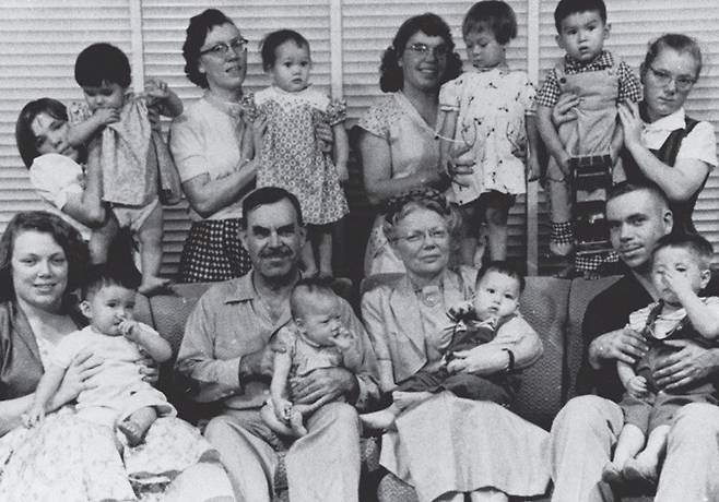 홀트 부부 가족이 한국에서 입양한 아이를 한 명씩 안고 기념촬영을 하고 있다. [홀트아동복지회 제공]