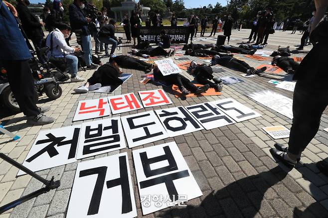 ‘모두를 위한 낙태죄 폐지 공동행동’ 회원들이 8일 오전 서울 종로구 청와대 분수대 앞에서 ‘정부의 형법, 모자보건법 개정안 입법예고안에 대한 입장 발표 기자회견’에서 바닥에 누워 손팻말을 들고 있다./우철훈 선임기자