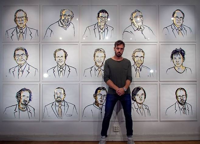 2019년 노벨상 수상자 15명의 초상화 앞에 선 그래픽 디자이너 니클라스 엘메헤드 (사진=니콜라스 엘메헤드 소셜미디어)