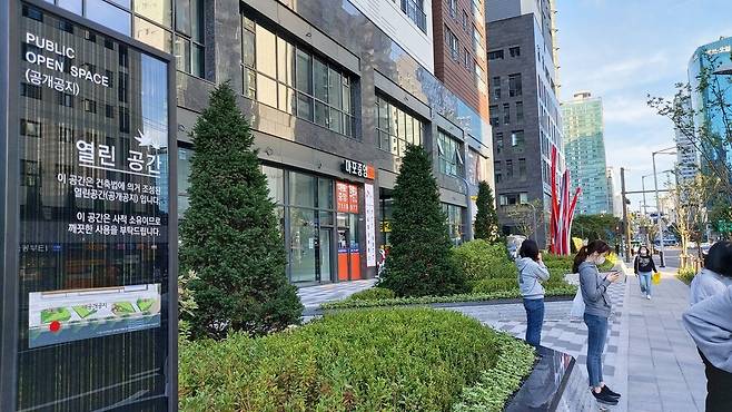 서울 마포구 한 대중교통 정류장 인근에 조성된 대형 건물 1층의 공개 공지. 시민들이 이용 가능하며 녹지 공간도 조성돼 있다. 김미향 기자