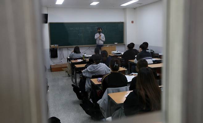 전국적으로 물리적(사회적) 거리 두기가 2단계에서 1단계로 하향 조정된 첫날인 12일 서울 마포구 홍익대 인근 거리가 시민들로 북적이고 있다(위 사진). 수능을 50여일 앞둔 이날 오랜만에 현장 수업을 재개한 서울 마포구의 한 대형학원에서는 강사가 마스크를 쓴 채 대면 강의를 하고 있다.  연합뉴스·권도현 기자