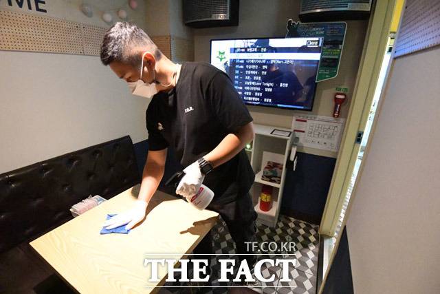 사회적 거리두기가 1단계로 완화된 가운데 13일 오후 서울 마포구 홍익대학교 인근 코인노래방에서 점주가 소독을 하며 영업을 준비하고 있다. /임세준 기자