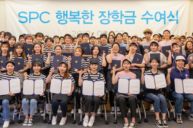 SPC그룹 매장에서 아르바이트를 한 대학생 100여명이 2018년 8월 서울 동작국 SPC 미래창조원에서 장학금을 받은 뒤 기념 사진을 찍고 있다. SPC그룹 제공