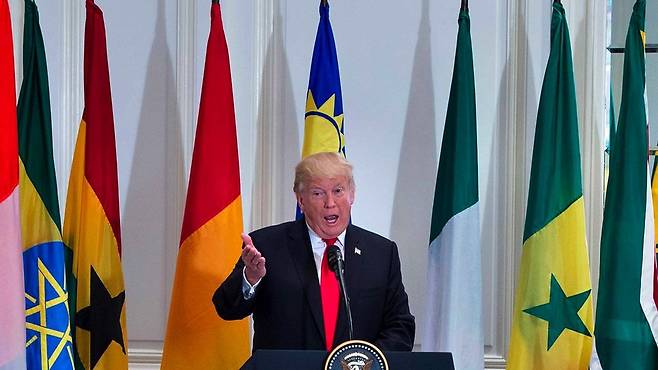 Donald Trump speaks with African flags in the background