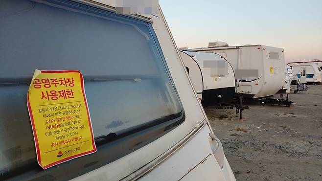 강원 강릉시가 공영 주차장을 장기간 차지하고 있는 캠핑카에 주차장 사용을 제한한다는 스티커를 부착해놨다. [촬영 이해용]