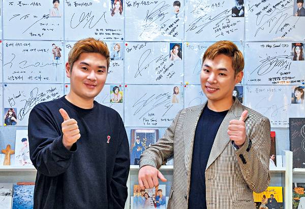 작사·작곡 그룹 ‘알고보니 혼수상태’의 김경범(왼쪽) 김지환씨가 서울 강남구 논현동 작업실에서 엄지를 치켜들고 밝게 웃고 있다.  신석현 인턴기자