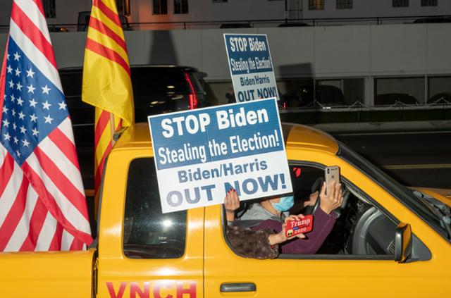 도널드 트럼프 미국 대통령 지지자들이 7일 캘리포니아주 로스앤젤레스 비버리힐스에서 '바이든은 선거를 빼앗지 말라'는 문구가 적힌 손팻말을 들고 항의 시위에 나서고 있다. 로스앤젤레스=EPA 연합뉴스