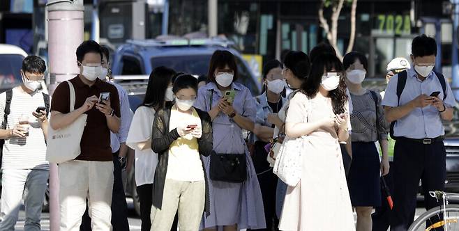 지난 8월 서울 광화문 네거리에 마스크를 쓴 채 출근하고 있는 시민들이 서 있다. 김혜윤 기자 unique@hani.co.kr