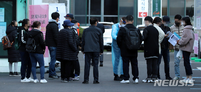 [서울=뉴시스] 이영환 기자 = 11일 오전 서울 중구 국립중앙의료원 코로나19 선별진료소에서 검사를 마친 시민들이 병원 관계자에게 영수증 등을 받고 있다. 2020.11.11. 20hwan@newsis.com