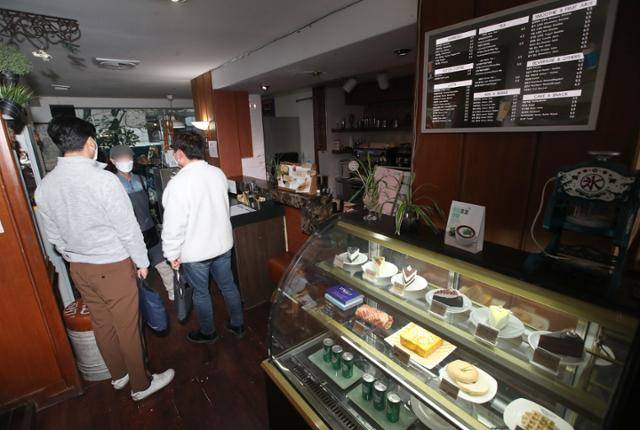 13일 부산 남구의 한 카페에서 부산시 감염병 총괄팀과 남구청이 카페 점주에게 마스크 착용 계도 활동을 하고 있다. 이날 부터 신종 코로나 바이러스 감염증(코로나19)방역을 위해 마스크 착용이 의무화 되며, 위반 시 10만 원 이하의 과태료가 부과된다. 2020.11.13/뉴스1