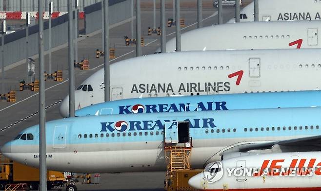 대한항공·아시아나 통합 국적항공사 출범 추진 (영종도=연합뉴스) 서명곤 기자 = 정부와 산업은행이 16일 대한항공의 아시아나항공 인수를 공식화했다.       국내 1, 2위를 합친 '글로벌 톱 10' 통합 국적항공사 출범을 추진하는 것이다.      16일 인천국제공항 계류장에 대한항공과 아시아나항공 항공기들이 서있다. seephoto@yna.co.kr