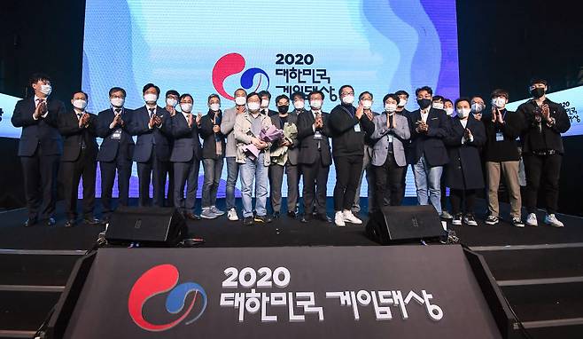 문화체육관광부가 주최하고 전자신문사, 스포츠조선이 후원한 2020 대한민국 게임대상 시상식이 18일 부산시 서면 부산e스포츠경기장에서 열렸다. 모바일 대규모다중접속역할수행게임(MMORPG) V4로 대상을 받은 박용현 넷게임즈 대표(앞줄 왼쪽 여덟번째)와 조승래 더불어민주당 의원(왼쪽 네 번째), 오영우 문화체육관광부 제1차관(왼쪽 다섯 번째), 이헌승 국민의힘 의원(왼쪽 열 번째), 홍승모 전자신문 이사 등 참석자들이 수상자들을 축하하며 기념촬영 하고 있다. 부산=박지호기자 jihopress@etnews.com