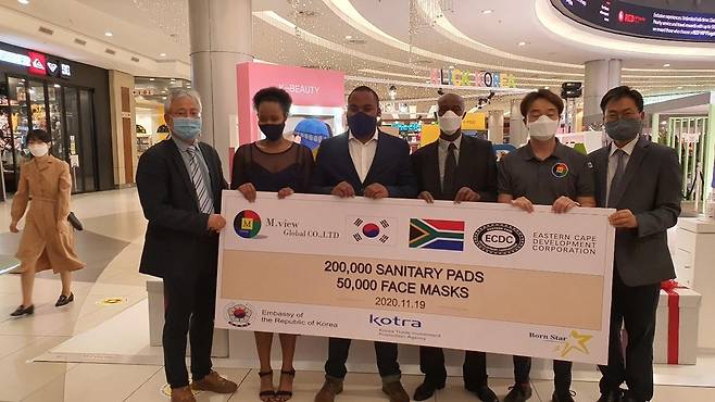 남아공에 여성위생용품 기부 (요하네스버그=연합뉴스) 김성진 특파원 = 19일(현지시간) 남아공 요하네스버그 샌튼시티몰의 체커스마트에서 K-소비재 수출대전 출범식을 계기로 강원 여성위생용품 '엠뷰글로벌'이 생리대 40만장과 마스크 10만장을 기부하는 패널을 들고 관계자들이 서 있다. 기부처는 이스턴케이프주 경제개발공사(ECDC)와 '오 그레이스랜드/걸스위드윙스'(O Grace Land/Girs With Wiings) 등 비정부기구(NGO) 2곳에서 기부를 받았으며 현지 취약계층 여성에게 배포된다. 2020.11.19. sungjin@yna.co.kr