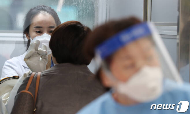 서울 중구 국립중앙의료원 선별진료소에서 의료진이 검체 채취를 하고 있다. 2020.11.20/뉴스1 © News1 이성철 기자