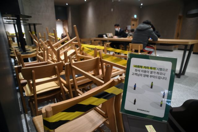 정부의 '사회적 거리두기' 2단계 시행을 하루 앞둔 23일 서울 중구 스타벅스 무교로점에 테이블과 의자가 치워져 있다. 거리두기 2단계에서 카페는 영업시간과 관계없이 포장·배달만 허용된다. 윤성호 기자