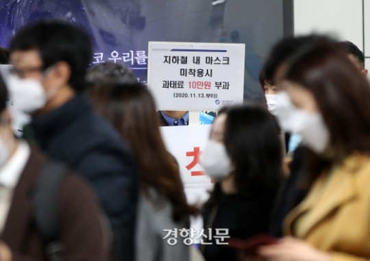 Employees of the Seoul metropolitan government and the Seoul Metro hold a placard encouraging citizens to wear masks when boarding the subway at Gwanghwamun Station on Line 5 of the Seoul Metro. / Kwon Do-hyun
