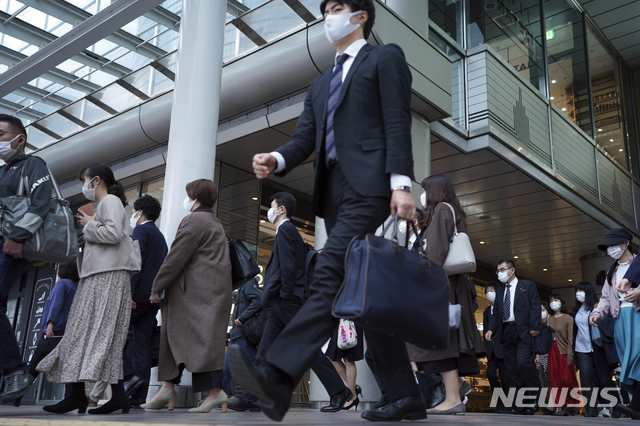 [도쿄=AP/뉴시스]20일 일본 도쿄의 한 지하철역 통로가 코로나19 확산 방지를 위해 마스크를 쓰고 출근하는 사람들로 붐비고 있다. 2020.11.20.