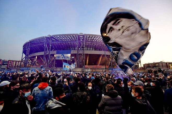 나폴리의 팬들이 27일 산 파올로 스타디움에 밖에서 전날 사망한 팀 레전드 디에고 마라도나의 사진과 깃발 등을 흔들며 그를 추모하고 있다. EPA연합뉴스