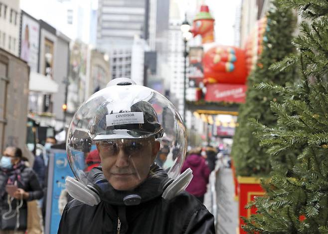 지난 25일(현지시간) 미국 뉴욕에서 메이시스 백화점의 추수감사절 퍼레이드를 앞두고 한 남성이 코로나19를 차단하기 위해 특수 아크릴 수지(플렉시그라스)로 만든 투명 헬멧을 머리에 쓰고 있다. (사진=EPA/연합뉴스 제공)