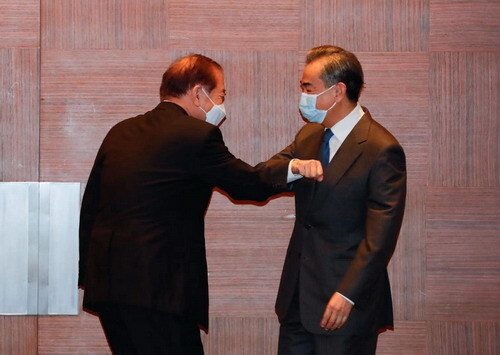 왕이 부장이 27일 오전 문정인 특보와 팔꿈치를 맞대며 인사를 나누고 있다. 중국 외교부 제공