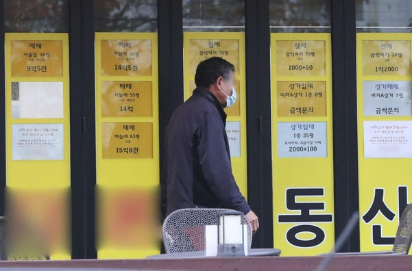지난 달 12일 부산 수영구 남천동 삼익비치 아파트 근처 부동산을 한 시민이 지나가고 있다. /김동환 기자