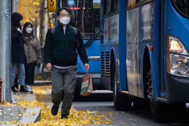 지난달 13일 서울 서대문구 모처의 정류장에서 한 남성이 정류장을 벗어나 정차한 버스를 따라잡기 위해 보도 바깥 차도 위를 걸어가고 있다.