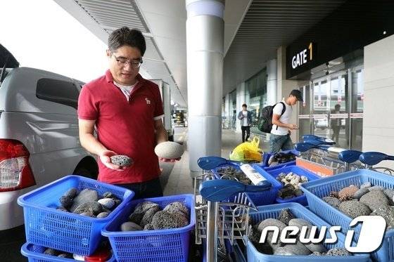 제주시 공무원들이 제주공항에서 회수된 돌들을 수거해 제주돌문화공원으로 옮기고 있다. /© 뉴스1 DB