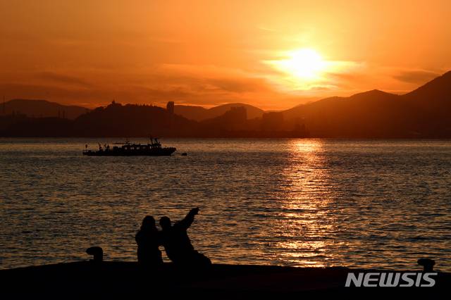 [남해=뉴시스]차용현 기자 = 찬바람이 불면서 기온이 뚝 떨어진 24일 오후 경남 남해군 남면 구미마을 인근에서 한 연인이 아름다운 석양을 바라보고 있다. 2020.11.24.  con@newsis.com