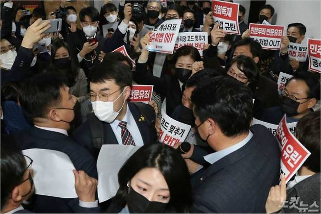 7일 오후 국민의힘 의원들이 더불어민주당의 고위공직자범죄수사처(공수처)법 개정안 등 입법 강행에 맞서 국회 법사위 회의실 앞에 집결해 규탄 구호를 외치는 가운데 민주당 김남국 의원이 국민의힘 의원들 사이를 뚫고 회의장으로 들어가고 있다. 윤창원기자