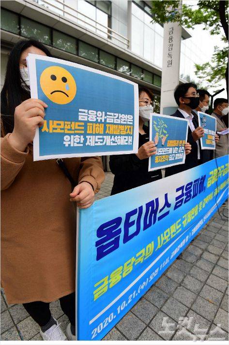 21일 오전 서울 여의도 금융감독원 앞에서 열린 ‘옵티머스 펀드 금융사기, 책임방기한 금융당국과 금융사 규탄’ 기자회견 참석자들이 손피켓을 들어보이고 있다. (사진=황진환 기자)