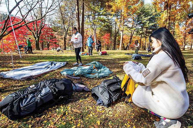 자전거와 만능 스포츠우먼으로 SNS에서 인기를 끌고 있는 봉지은씨가 텐트 설치 설명서를 읽고 있다.