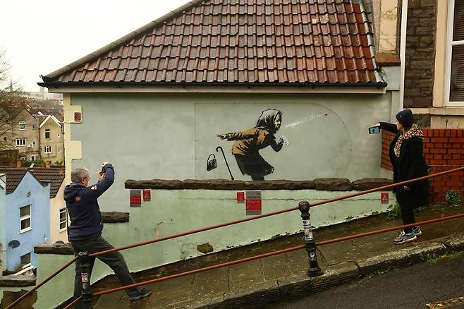 뱅크시의 새 벽화 앞에서 기념사진을 찍는 사람들. 사진=AFP 연합뉴스