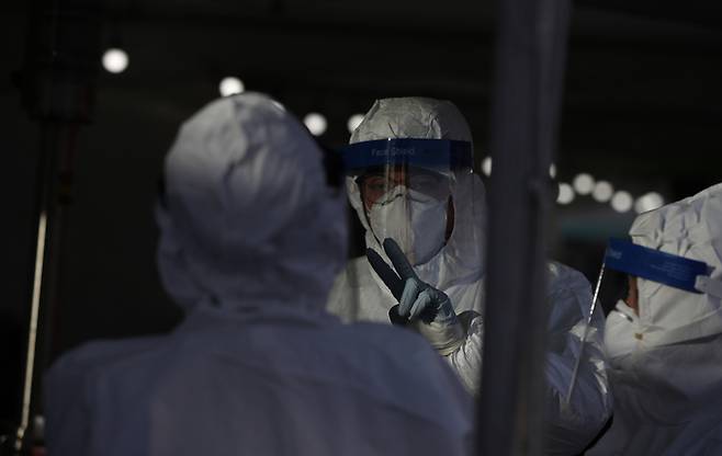 16일 오후 서울 중구 서울역 임시선별검사소에서 의료진이 신종 코로나 바이러스 감염증(코로나19) 검사를 하던 중 대화를 나누고 있다. 뉴시스