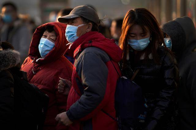 6일 중국 베이징의 한 버스 정류장에서 마스크를 쓴 채 줄을 선 노년부부 뒤로 한 여성이 지나가고 있다. 베이징=AP 연합뉴스