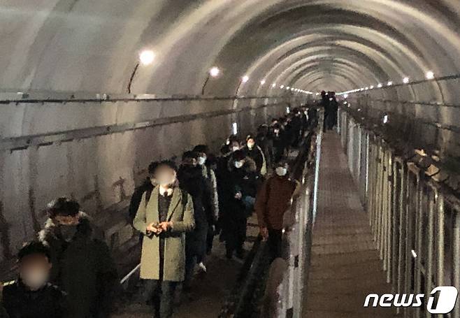 21일 오후 6시 30분께 김포 골드라인 경전철이 김포공항역에서 고촌역사이에서 멈춰서 시민들이 큰 불편을 겪고 있다. 이 차량에 50여분간 갇혀 있던 약 300여명의 승객들이 열차 선로 위 비상통로로 고촌역까지 걸어가고 있다. 2020.12.21/뉴스1 © News1 김명섭 기자