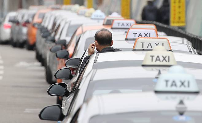 최근 신종 코로나바이러스 감염증(코로나19) 재확산으로 이동과 모임이 줄어 승객이 감소한 택시들이 지난달 말 서울역 인근 도로에서 승객을 기다리며 길게 줄지어 서 있다. [연합]