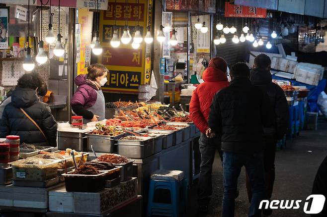 정부가 코로나19로 피해가 집중된 소상공인·자영업자에게 임대료 포함 최대 300만원 지원을 결정한 27일 서울시내 한 전통시장을 찾은 시민들이 상점을 둘러보고 있다. 2020.12.27/뉴스1 © News1 유승관 기자