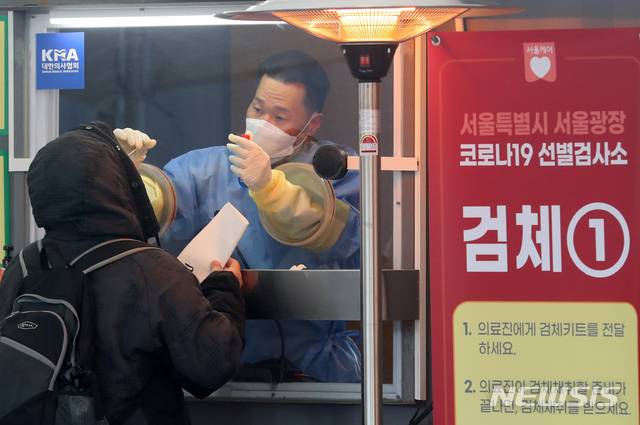 [서울=뉴시스]배훈식 기자 = 전국 곳곳에 한파 특보가 내려진 30일 오전 서울 중구 서울시청 광장에 설치된 신종 코로나바이러스 감염증(코로나19) 임시 선별검사소에서 한 의료진이 검체를 채취하고 있다. 2020.12.30. dahora83@newsis.com