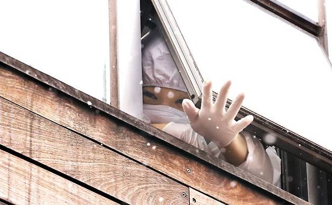 29일 코호트 격리된 서울 구로구의 한 요양병원에서 함께 격리된 간호사가 외부 취재진을 향해 손을 흔들고 있다.