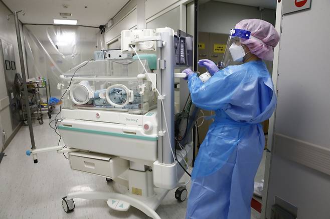 지난 30일 국민건강보험 일산병원에서 코로나에 걸린 산모가 낳은 2.9㎏ 남자아이가 인큐베이터에 실려 음압격리병실을 나서고 있다. /일산병원