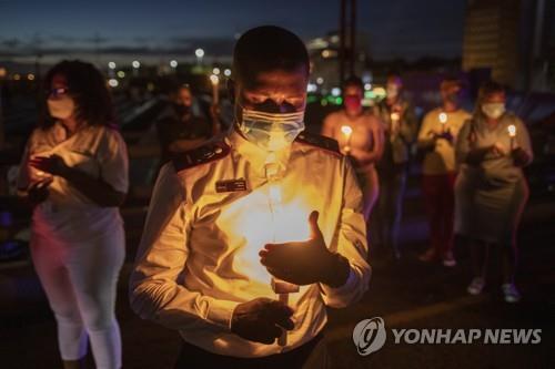 지난달 31일 남아공 요하네스버그에서 코로나19 희생자 추모 촛불을 든 사람들 [EPA=연합뉴스]