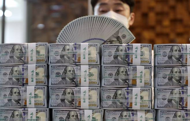 사진은 서울 명동 하나은행 본점에서 직원이 미국 달러를 살펴보는 모습. [연합]