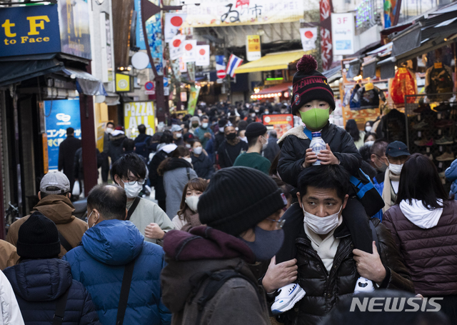 [도쿄=AP/뉴시스]새해를 앞둔 12월31일 오후 코로나19 확산 방지를 위해 마스크를 쓴 일본 도쿄 시민들이 상가에 몰려 새해맞이 장을 보고 있다. 2020.12.31.