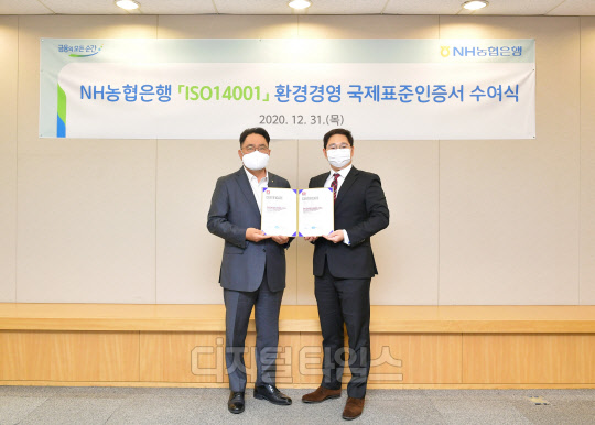 지난달 31일 서울시 중구에 위치한 농협은행 본점에서 NH농협은행 지준섭 농업·녹색금융부문 부행장(왼쪽)과 로열서트코리아 이권상 대표가 ISO 14001 인증서 수여식을 갖고 기념촬영을 하고 있다. (농협은행 제공)