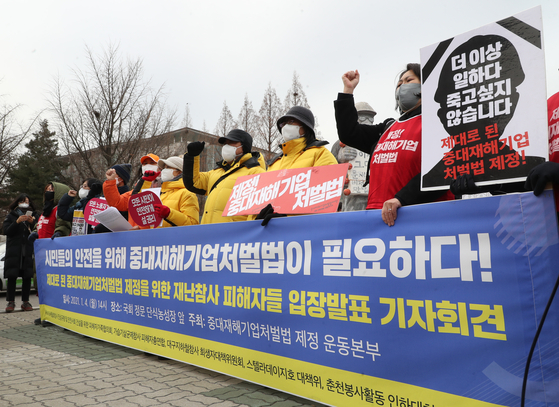 A group of people stage a protest to advocate the passage of a bill aimed at toughening penalties for industrial accidents on Monday at the National Assembly in Yeouido, western Seoul. [YONHAP]